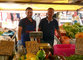 Padre e figlio dietro al loro banco di frutta e verdura al mercato Appio I
